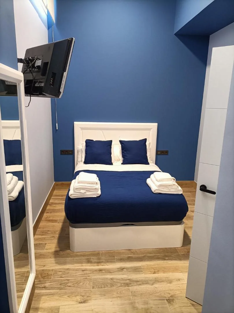 Dormitorio con cabecero y toallas